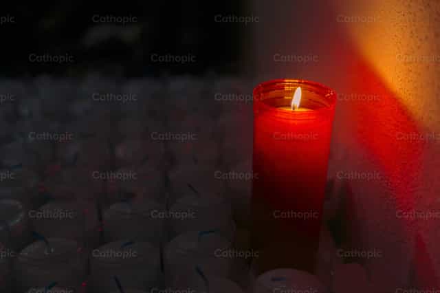 Vela roja encendida para ofrendas - Banco de imágenes católicas - Fotografía por Diócesis de Córdoba