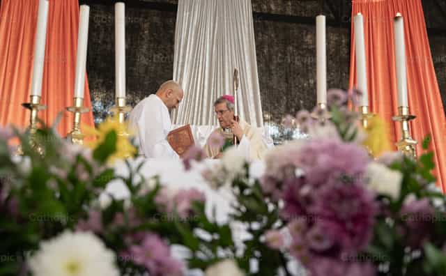 Un obispo entre flores y velas - Banco de imágenes católicas - Fotografía por Carolina BR