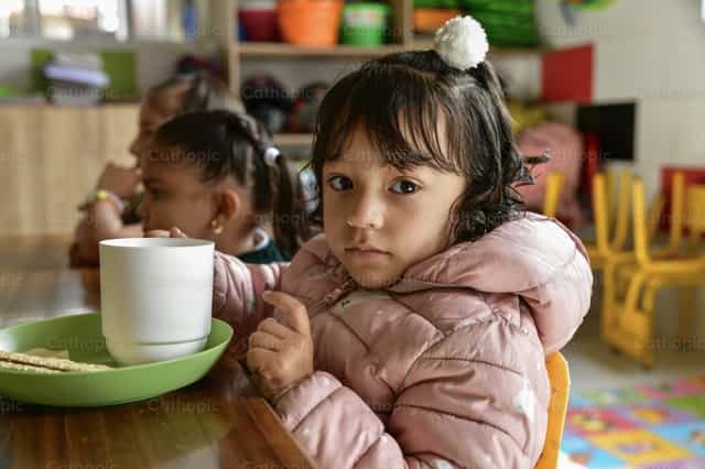 Girl eating her food - Catholic stock images - Photo by Carolina BR