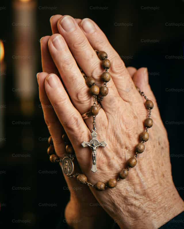 Manos en oracion con rosario de madera - Banco de imágenes católicas - Fotografía por Noemí Márquez