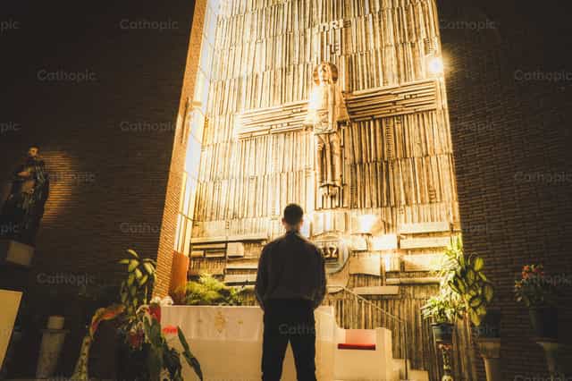 Sacerdote rezando ante el altar - Banco de imágenes católicas
