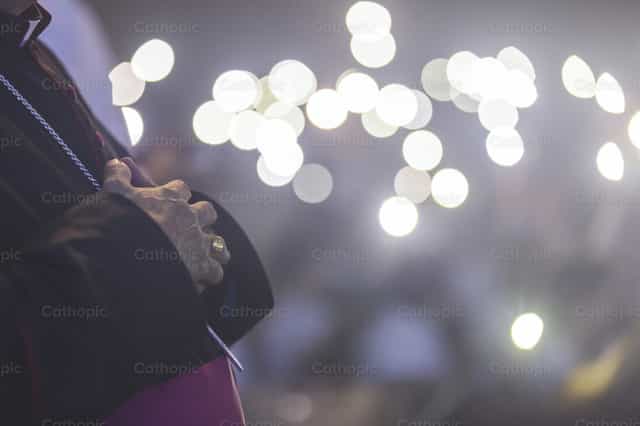 As mãos do bispo em oração com anel episcopal - Imagens católicas de stock