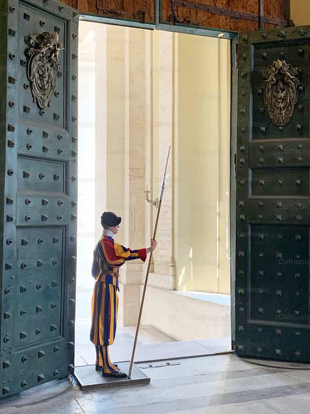 Zwitserse garde bij de wijd open poort in Vaticaanstad - Katholieke stockfoto's