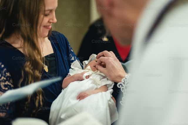 Sacerdote le da a un bebé una pizca de sal bendita - Banco de imágenes católicas - Fotografía por Carlos Sierra