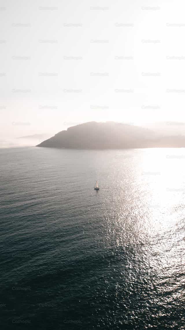 Barco navegando en el mar frente a la isla de Deva - Banco de imágenes católicas - Fotografía por Santiago de la Hoz