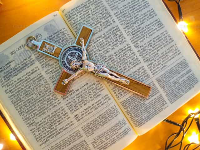 Offenes Buch und Kreuz des hl. Benedikt - Katholische Stockfotos