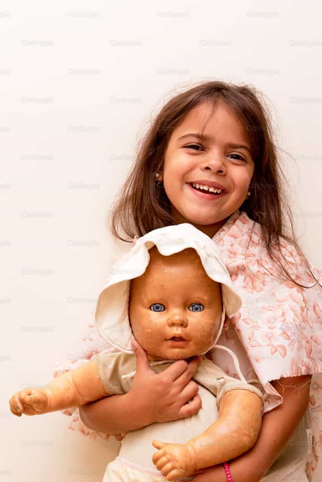 Menina pequena com sua boneca - Imagens católicas de stock - Foto de Pitangus Alfonso Asensio