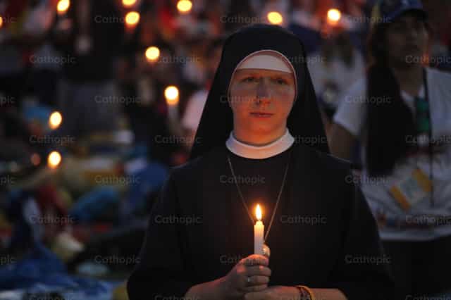 Irmã religiosa segurando uma vela - Imagens católicas de stock