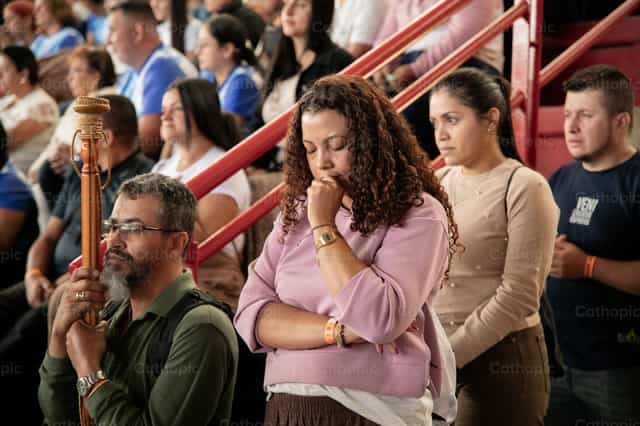 Mulher em oração durante a celebração - Imagens católicas de stock