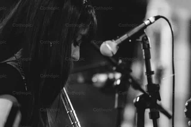 Chica tocando flauta en el coro - Banco de imágenes católicas