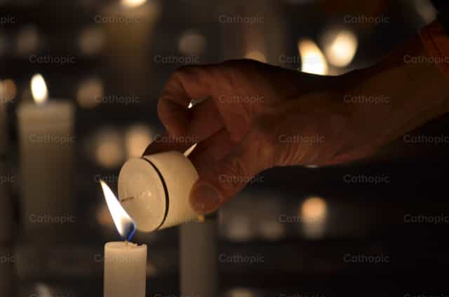 Accendere una candela - Immagini stock cattoliche