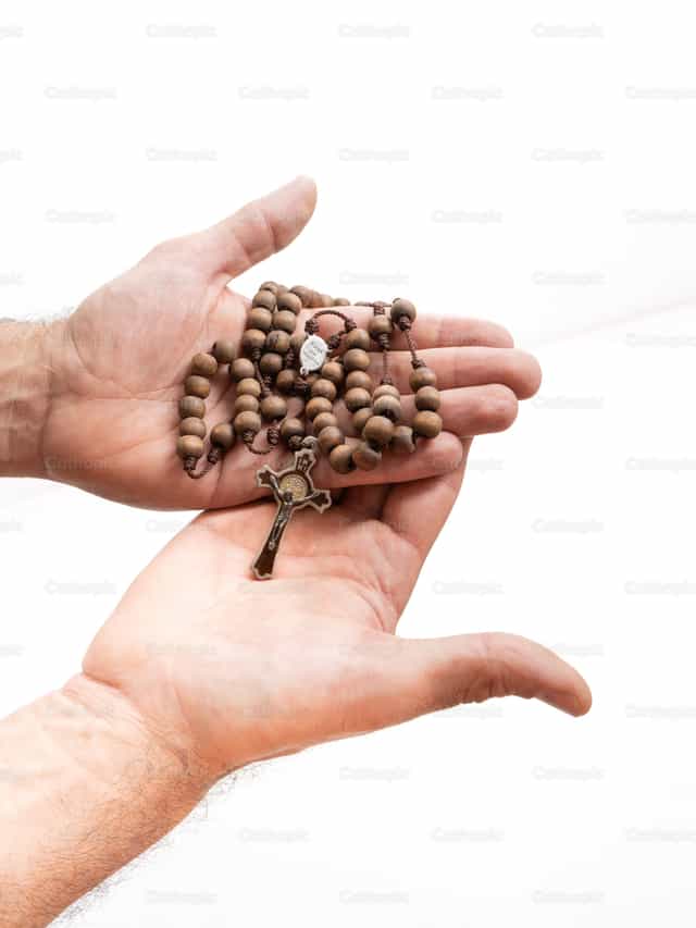 Rosary in the hands of a man - Catholic stock images