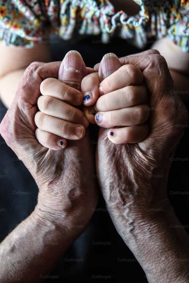 Las manos de una abuela y su bisnieta - Banco de imágenes católicas - Fotografía por Luisa Oswalt
