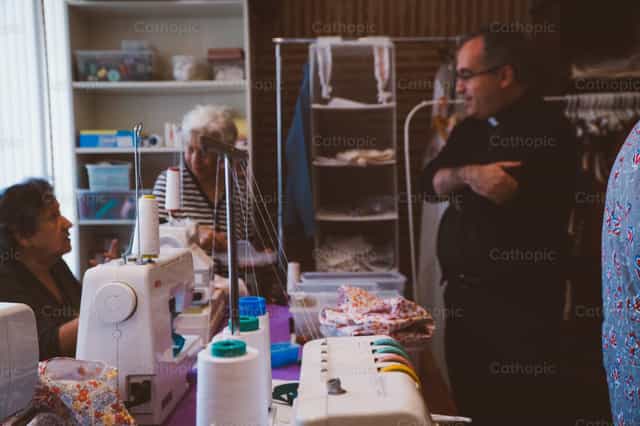 Priest in conversation with parish employees - Catholic stock images - Photo by Almures Studio