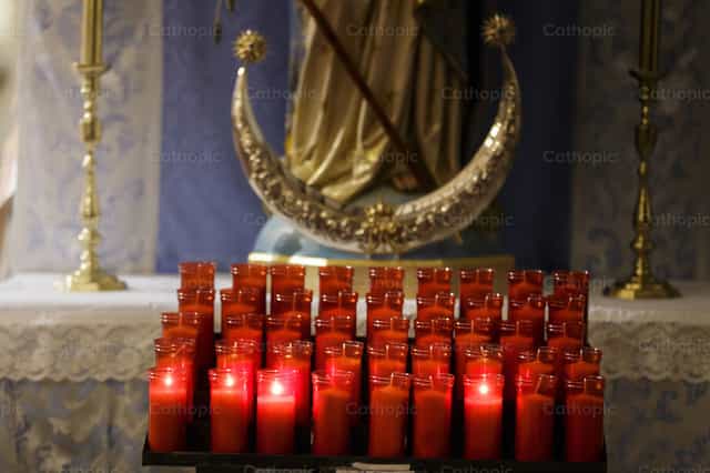 Red candles for offerings in a parish - Catholic stock images - Photo by Diócesis de Córdoba