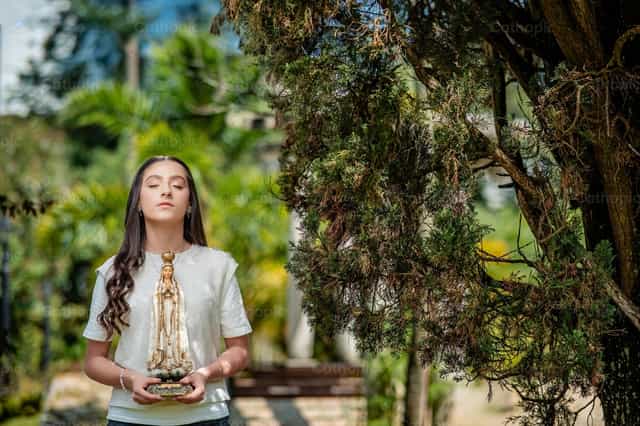 Niña con una imagen de Nuestra Señora de Fátima - Banco de imágenes católicas