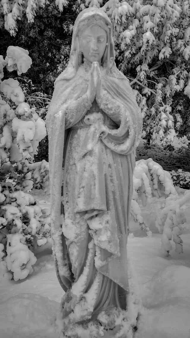 Estátua da Virgem na neve - Imagens católicas de stock