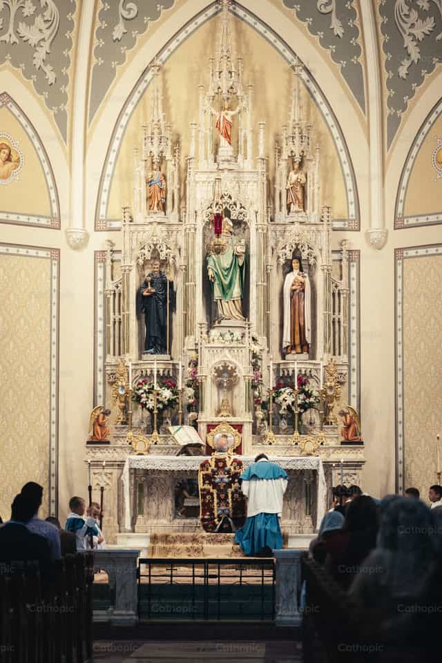 El sacerdote hace una genuflexión antes de la consagración - Banco de imágenes católicas - Fotografía por Carlos Sierra