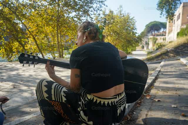 Chica tocando la guitarra en un parque - Banco de imágenes católicas - Fotografía por Lupe Belmonte