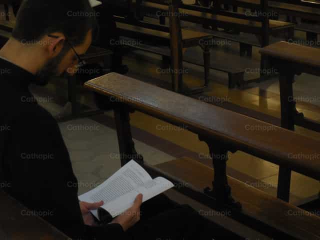 Leggere e pregare in chiesa - Immagini stock cattoliche