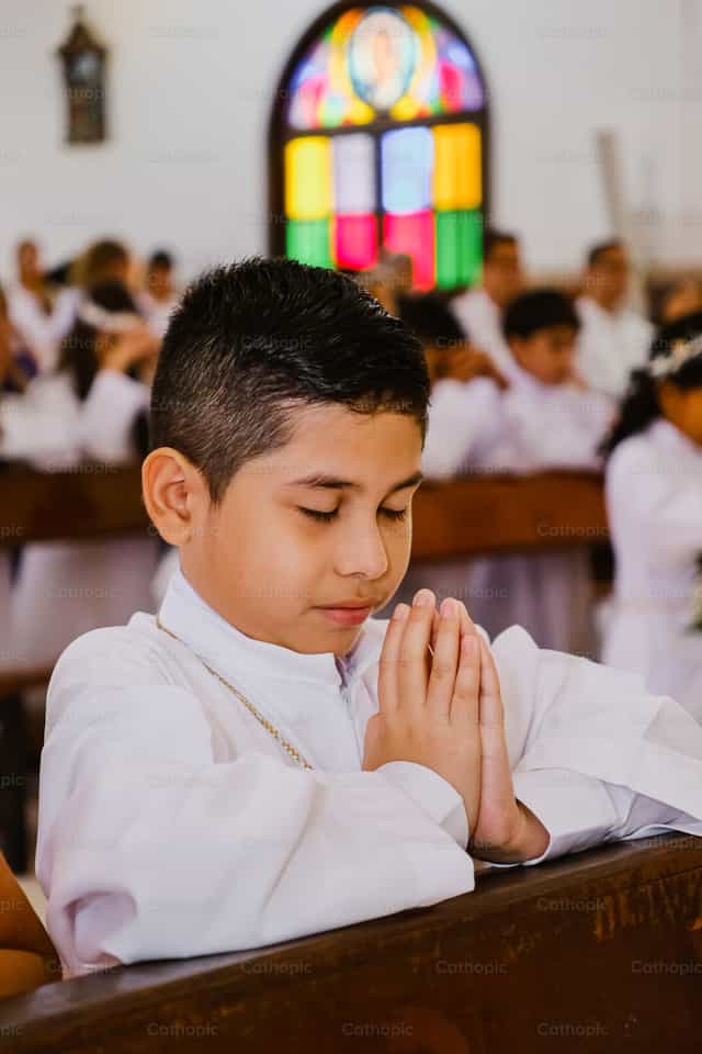 Niño rezando en su Primera Comunión - Banco de imágenes católicas - Fotografía por Leider Mendoza
