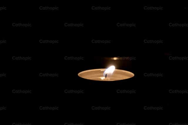 Vela en la oscuridad - Banco de imágenes católicas - Fotografía por Jakov Pleše