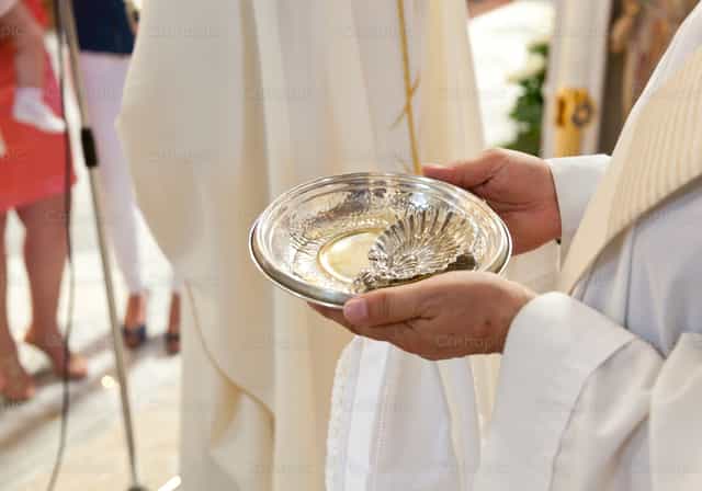 Sacerdote segurando uma tigela de prata - Imagens católicas de stock