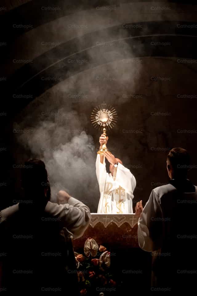 Eucharistic adoration - priest blessing - Catholic stock images - Photo by Jakov Pleše