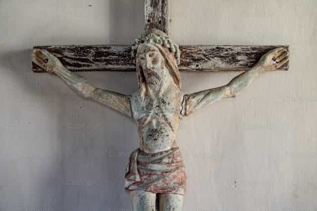 Antigo crucifixo de madeira entalhada montado na parede - Imagens católicas de stock