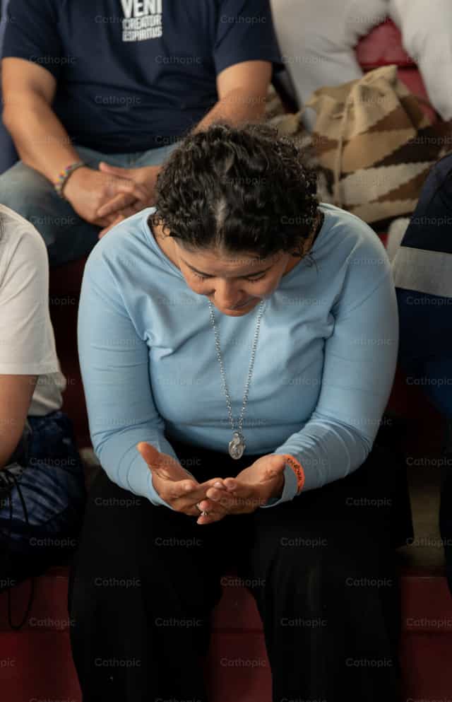 Mulher em oração com as mãos abertas - Imagens católicas de stock
