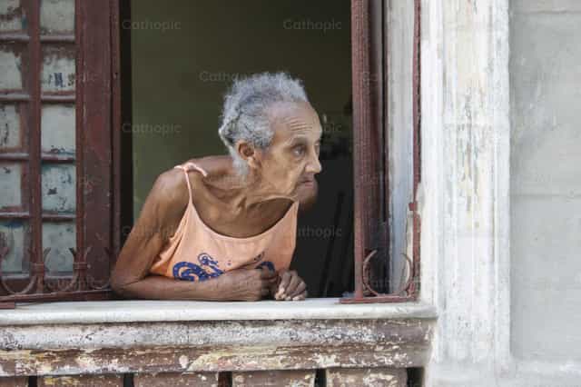 Mujer pobre mirando desde su ventana - Banco de imágenes católicas - Fotografía por Yandry Fernández Perdomo