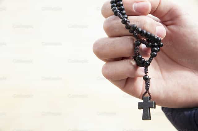 Hand holding a rosary in an attitude of prayer. - Catholic stock images - Photo by Diócesis de Córdoba