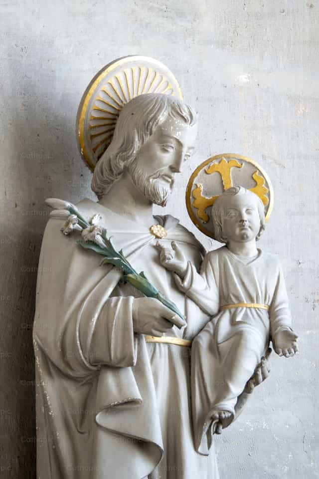 Estatua de San José sosteniendo al Niño Jesús - Banco de imágenes católicas - Fotografía por Joan Sutter