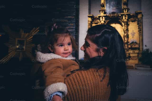 Mutter und Tochter beten vor dem Altar - Katholische Stockfotos