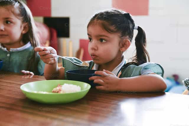 Girl eating her food - Catholic stock images - Photo by Carolina BR