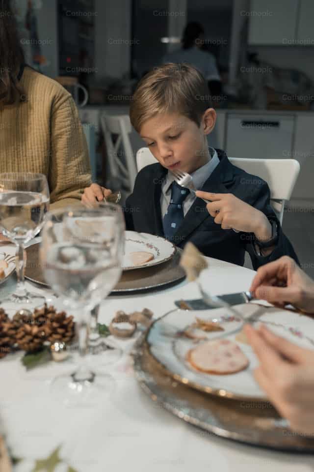 Criança aproveitando o jantar de Natal - Imagens católicas de stock - Foto de Almures Studio