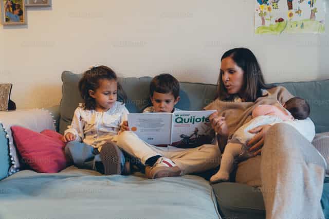 Moeder leest verhalen voor aan haar kinderen - Katholieke stockfoto's