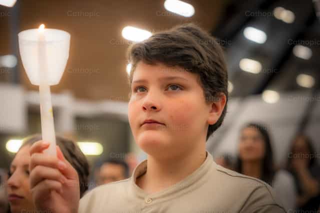 Jeune personne tenant une bougie - Images catholiques de stock