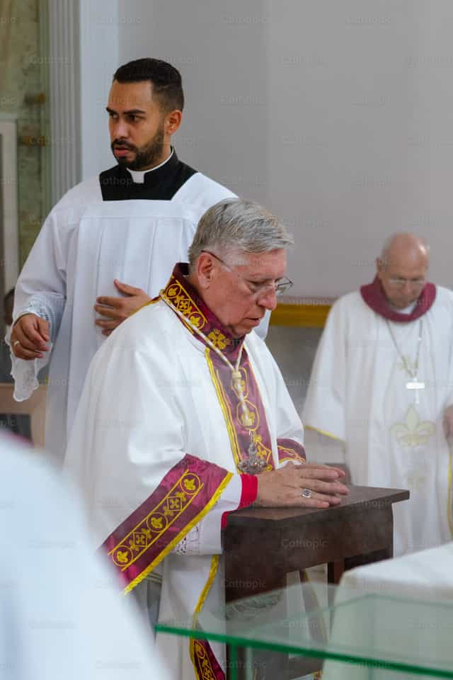 Évêque à genoux en prière - Images catholiques de stock