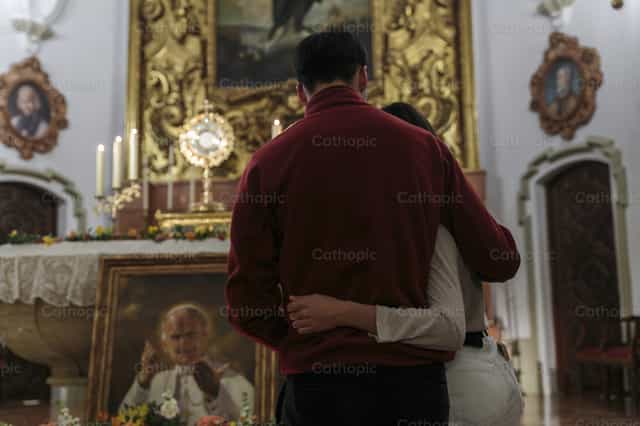 Joven pareja rezando ante el Santísimo Sacramento - Banco de imágenes católicas - Fotografía por Diócesis de Córdoba