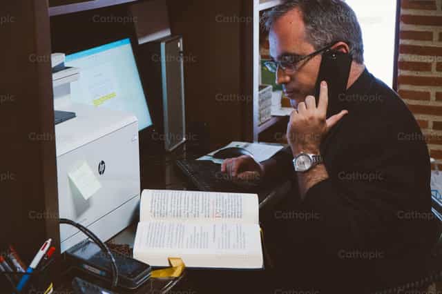 Priest calling on the phone - Catholic stock images - Photo by Almures Studio