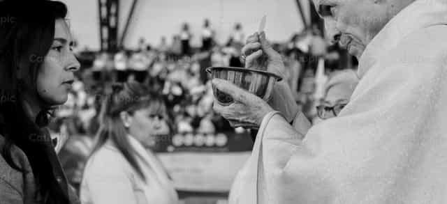 Sacerdote distribuyendo la Sagrada Comunión - Banco de imágenes católicas - Fotografía por Carolina BR