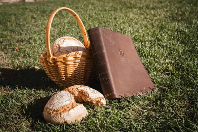 Bíblia e cesta de pães - Imagens católicas de stock