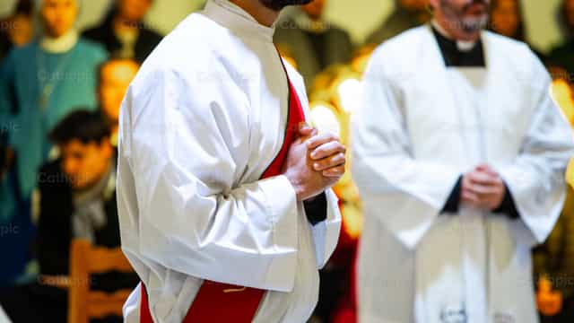 Manos de sacerdote orando durante ordenación - Banco de imágenes católicas