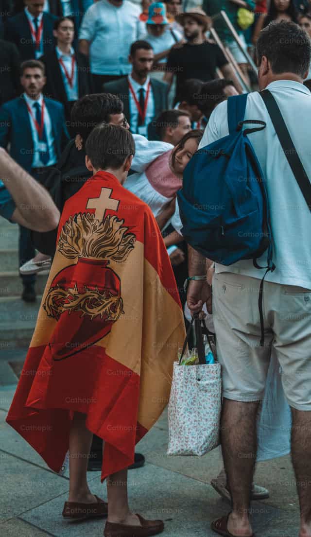 Joven con la bandera del Sagrado Corazón de Jesús - Banco de imágenes católicas