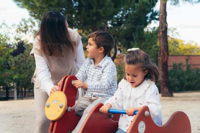 Mutter und Kinder spielen im Park - Katholische Stockfotos