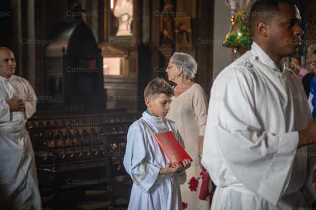 Monaguillo con el misal de la liturgia en procesión - Banco de imágenes católicas