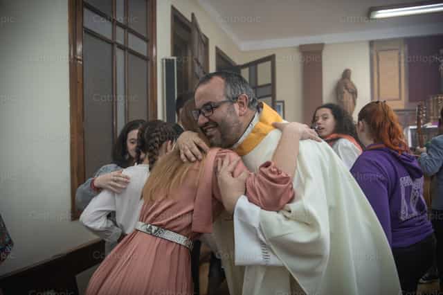 Sacerdote abraza a un fiel en la iglesia - Banco de imágenes católicas - Fotografía por Yandry Fernández Perdomo