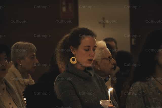 Woman praying at Easter Vigil mass - Catholic stock images