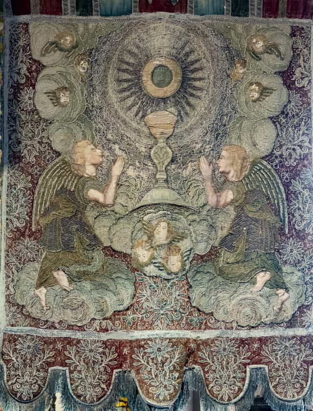 Dos ángeles se arrodillan en oración junto a un cáliz sagrado - Banco de imágenes católicas